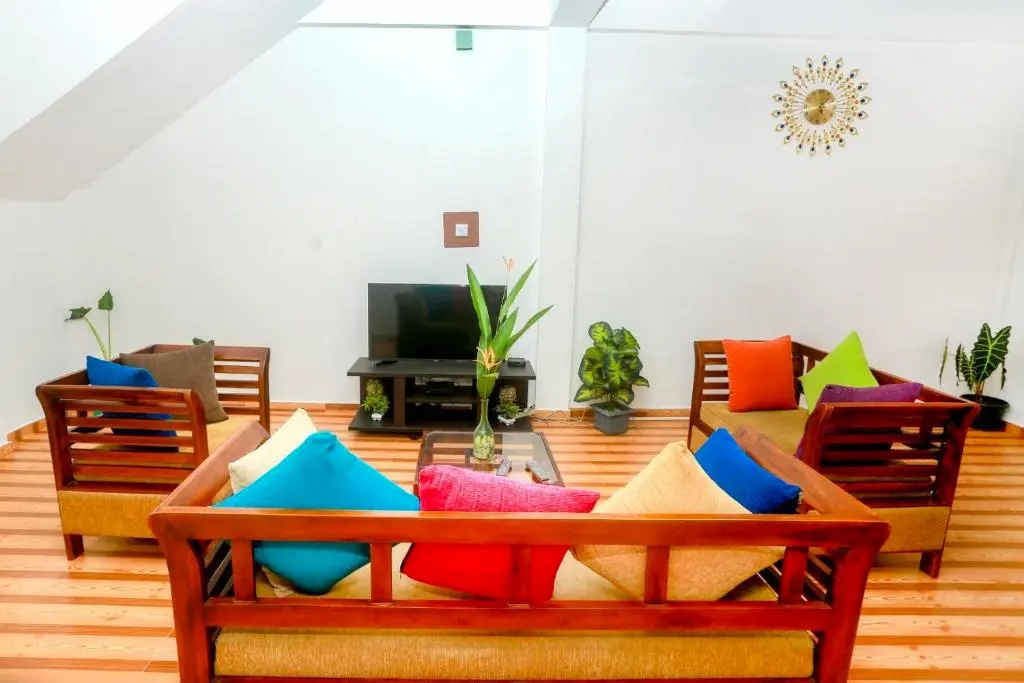 Apartment lounge with teak sofas and bright cushions
